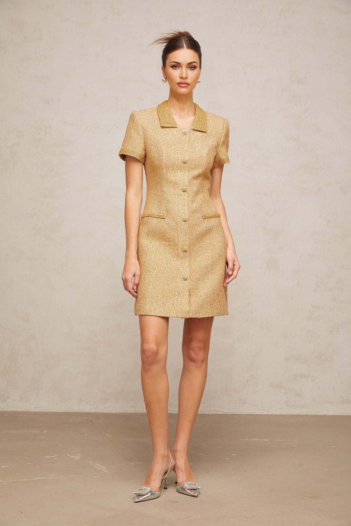 Woman wearing short gold dress with sequins and tweed texture