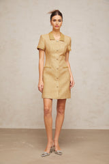 Woman wearing short gold dress with sequins and tweed texture