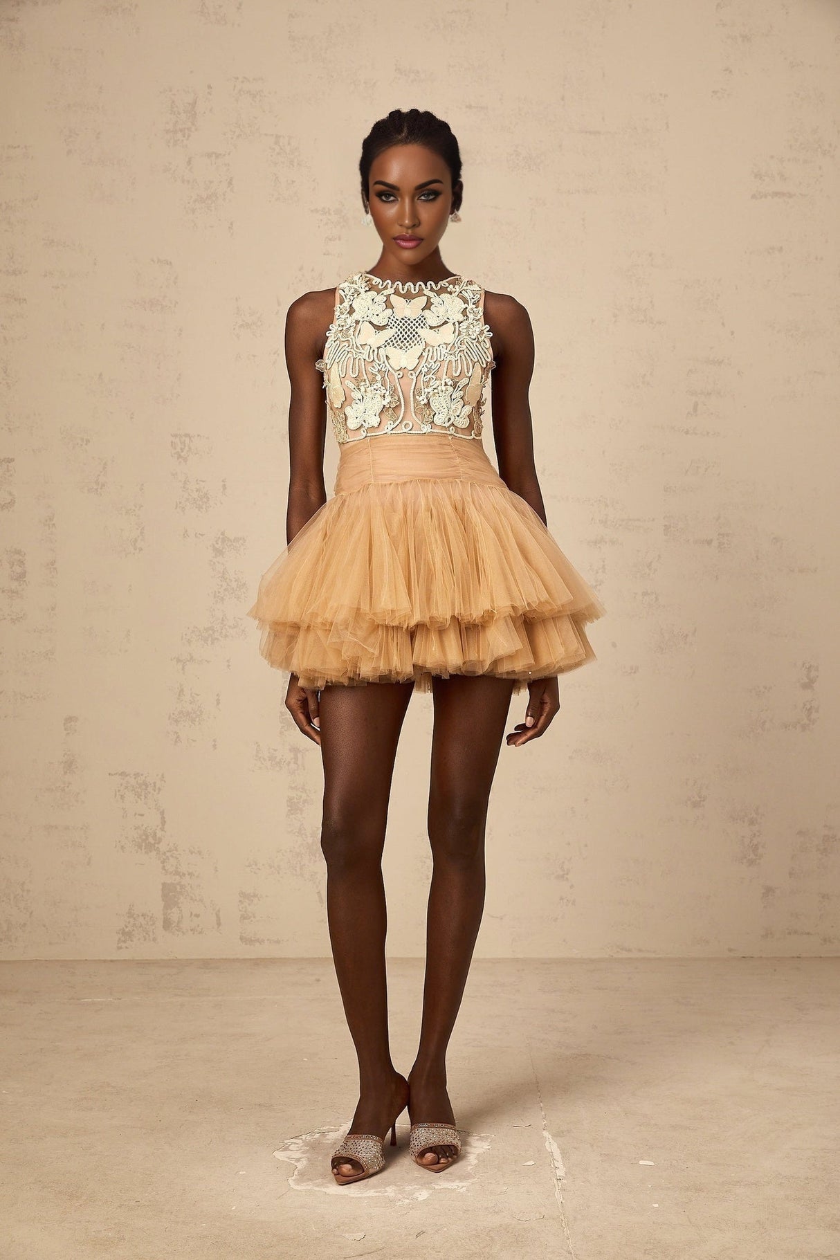 Woman wearing short khaki dress with embellished lace panels and tulle skirt
