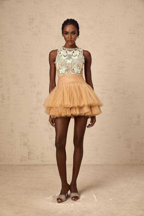 Woman wearing short khaki dress with embellished lace panels and tulle skirt