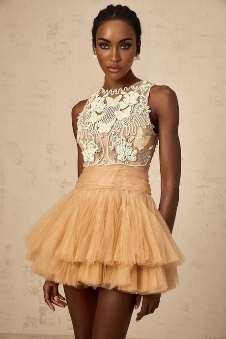 Woman wearing short khaki dress with lace panel and embellishments on tulle fabric