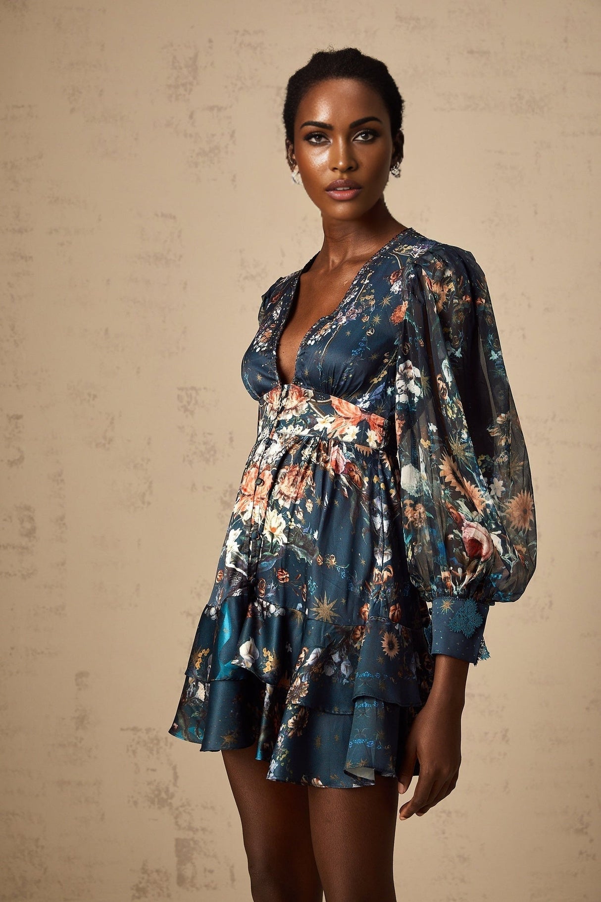Woman wearing short light blue dress with graphic print pattern and embellishments
