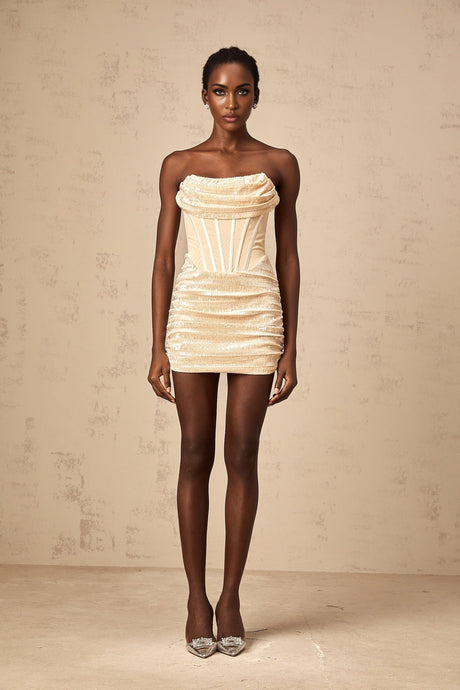 Woman wearing short neutral colored tulle dress with sequin embellishments