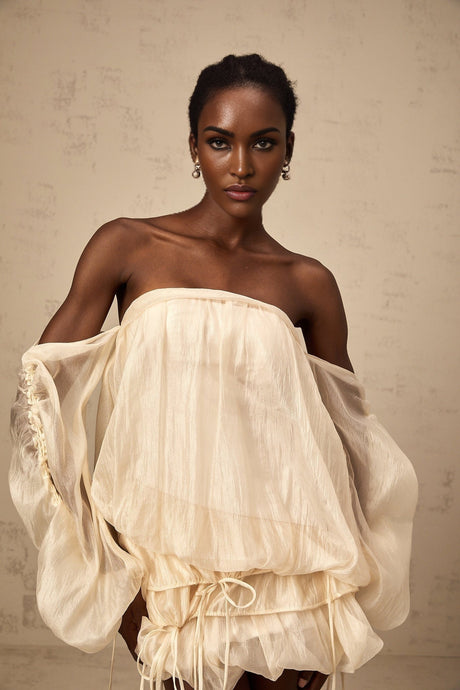 Woman wearing short offshoulder dress with ruched layered fabric and selftie detail