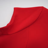 Woman wearing short red mini dress with cap sleeves standing against plain background