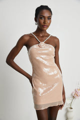 Woman wearing short sparkly dress with floral pattern and sequin embellishments