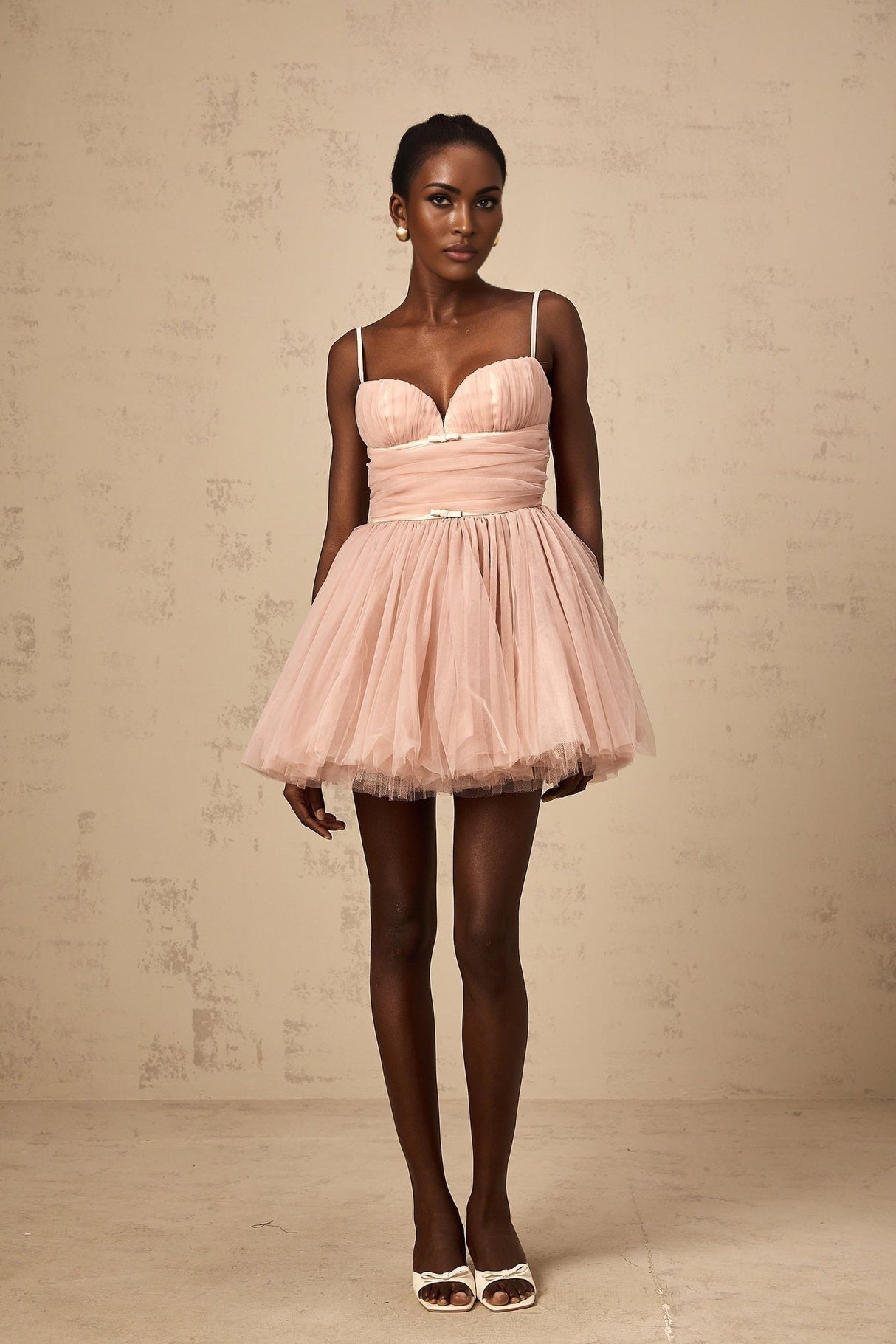 Woman wearing short white sleeveless dress with pleated tulle skirt