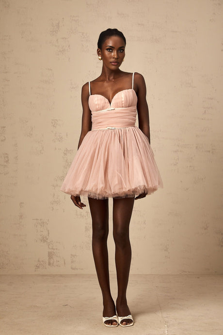 Woman wearing short white sleeveless dress with pleated tulle skirt