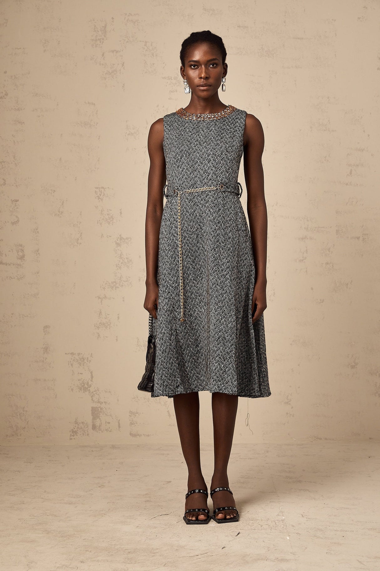 Woman wearing sleeveless grey tweed midi dress with crystal embellishments for Valentines Day occasion