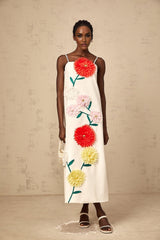 Woman wearing sleeveless white midi dress with 3d petal details on bodice