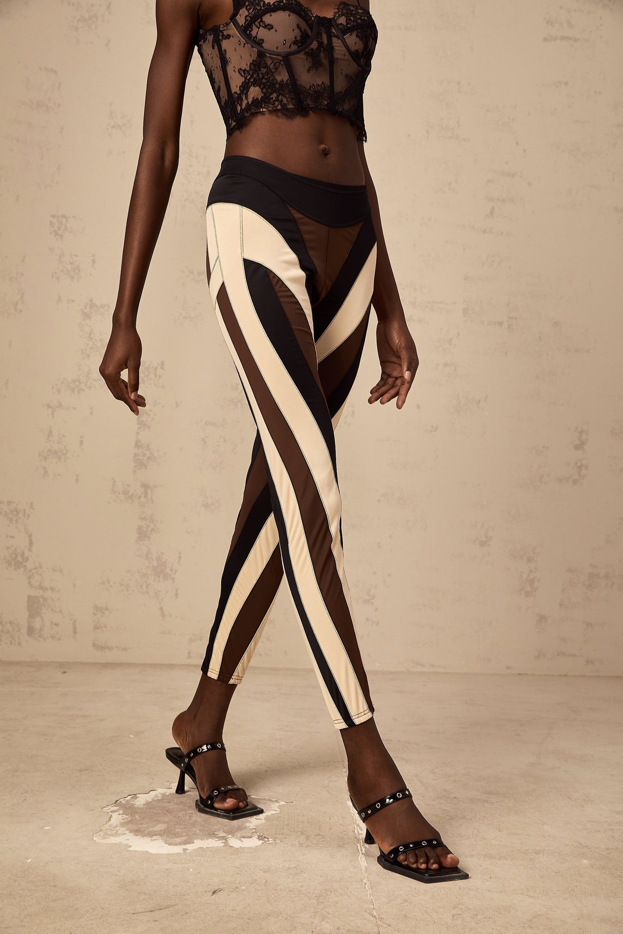 Woman wearing spiral color block panelled leggings in vibrant colors with a swirling pattern on the legs