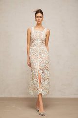 Woman wearing white Aline midi dress with floral lace pattern standing in neutral background