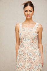 Woman wearing white Aline midi dress with floral lace pattern standing in neutral pose