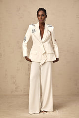 Woman wearing white blazer and trousers set with butterfly applique embellishments