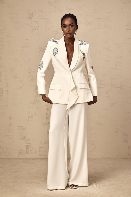 Woman wearing white blazer and trousers set with butterfly applique embellishments
