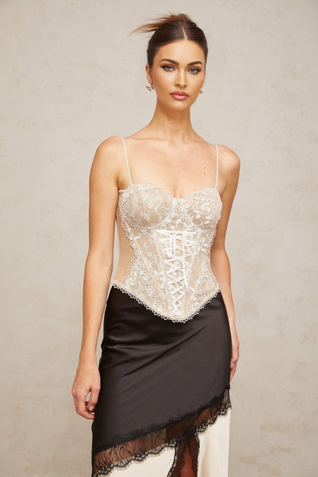 Woman wearing white bustier top with floral lace panelling and thin shoulder straps