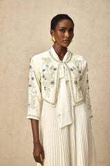 Woman wearing white embellished jacket and pleated dress matching set named Blanche