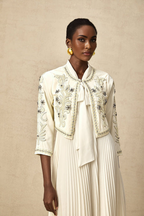 Woman wearing white embellished jacket and pleated dress matching set named Blanche