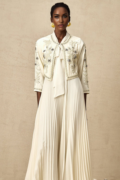 Woman wearing white embellished jacket with pleated details and matching dress Blanche brand formal outfit set