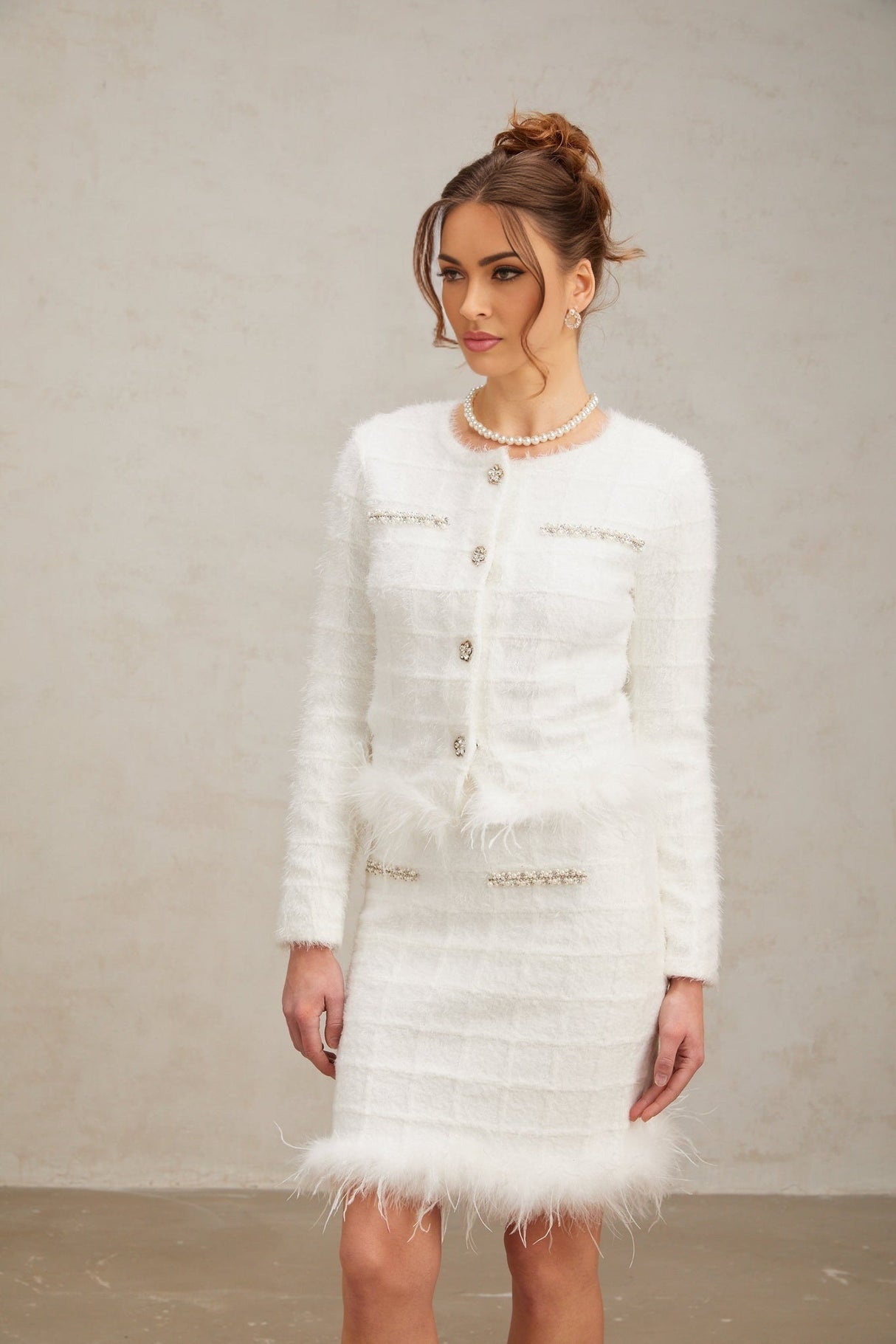 Woman wearing white feather waffle knit cardigan and matching skirt set