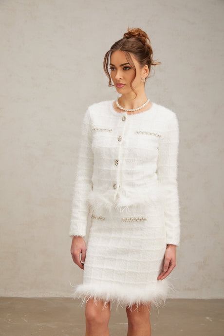 Woman wearing white feather waffle knit cardigan and matching skirt set