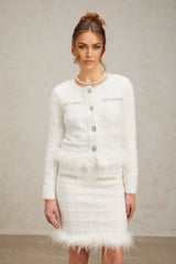 Woman wearing white feather waffle knit cardigan and matching skirt set