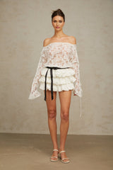 Woman wearing white floral lace top and matching skirt set called Aveline