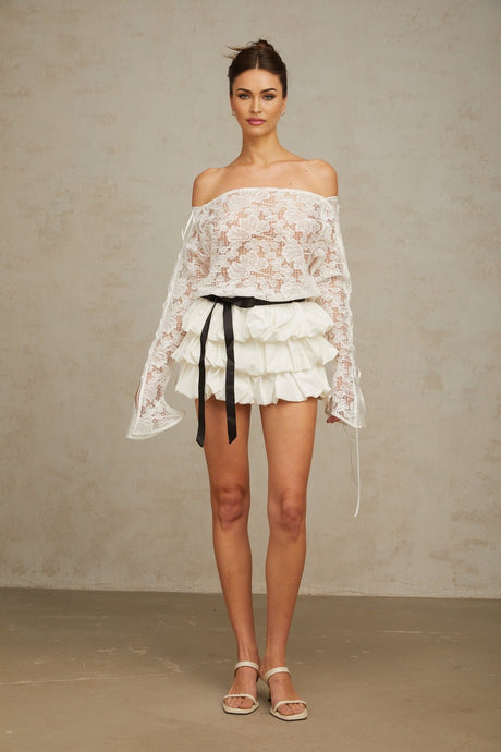 Woman wearing white floral lace top and matching skirt set called Aveline