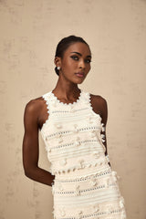 Woman wearing white knit top and skirt set with pointelle trim details Paola matching outfit against plain background
