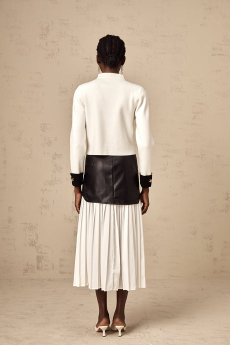 Woman wearing white knitted jacket with contrasting color details and open front design