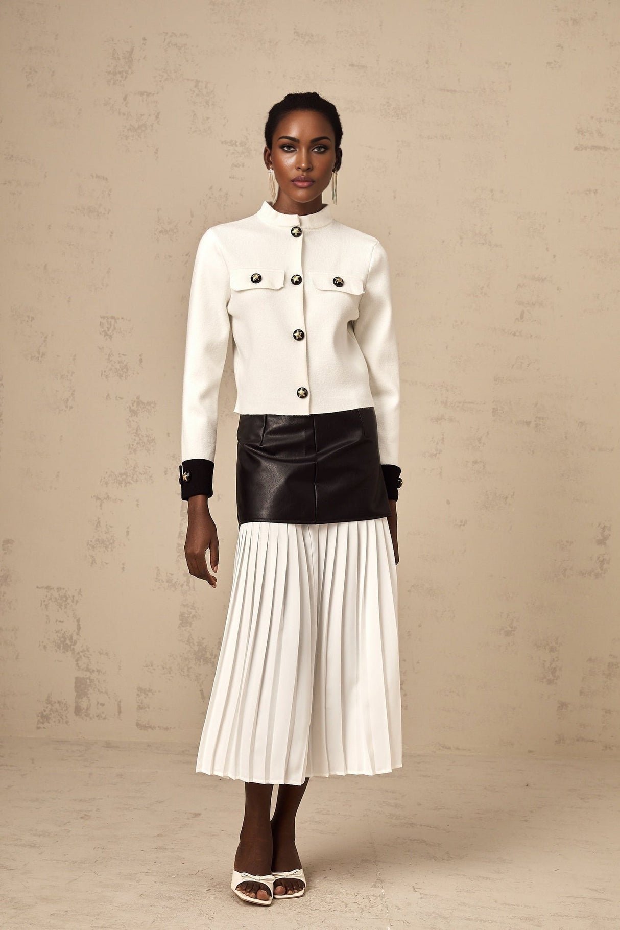 Woman wearing white knitted jacket with contrasting color details and zipper closure