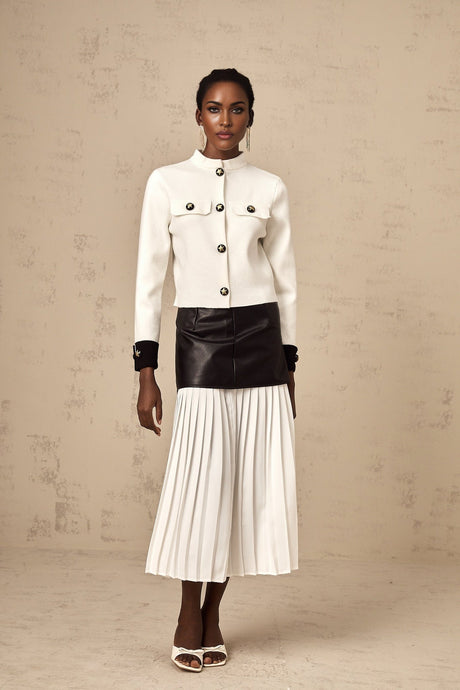 Woman wearing white knitted jacket with contrasting color details and zipper closure