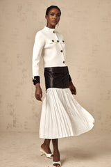 Woman wearing white knitted jacket with dark contrasting trim and details