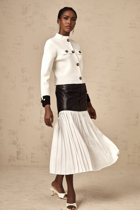 Woman wearing white knitted jacket with dark contrasting trim and details