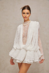 Woman wearing white lace matching set consisting of top shorts and dress Semi sheer fabric with floral lace pattern Elegant summer outfit