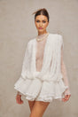 Woman wearing white lace matching set consisting of top shorts and dress Semi sheer fabric with floral lace pattern Elegant summer outfit