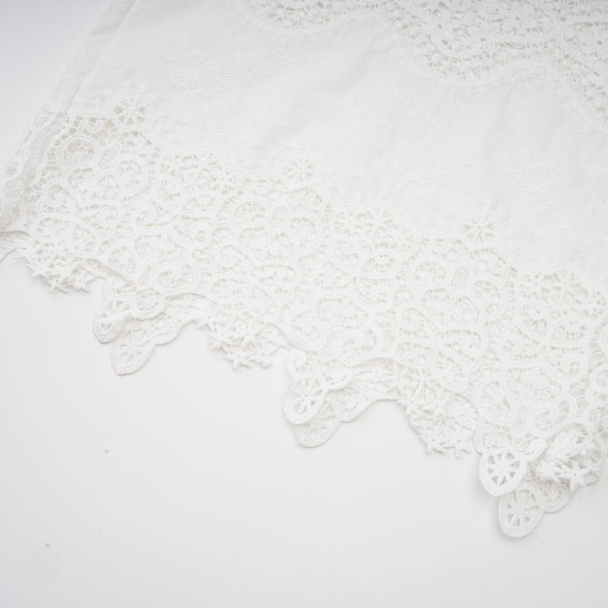 Woman wearing white lace trim cropped top and matching trousers with cutout details Raphaelle matching set