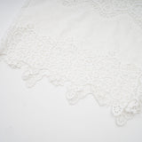 Woman wearing white lace trim cropped top and matching trousers with cutout details Raphaelle matching set