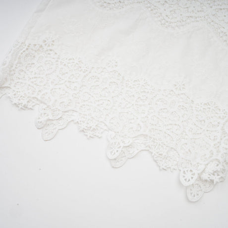 Woman wearing white lace trim cropped top and matching trousers with cutout details Raphaelle matching set