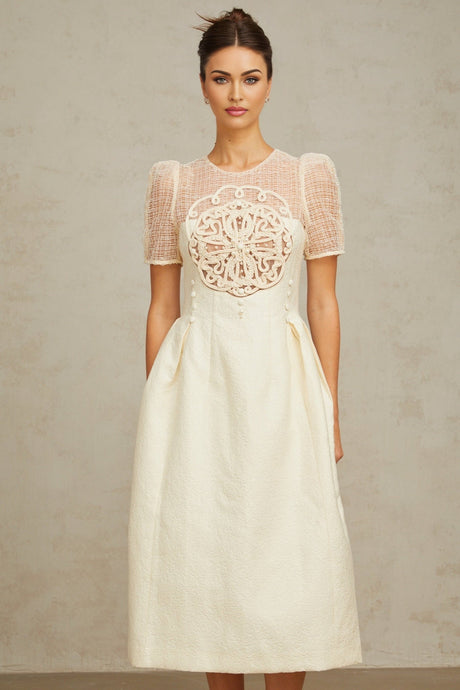 Woman wearing white midi dress with braided panelling and sleeveless design