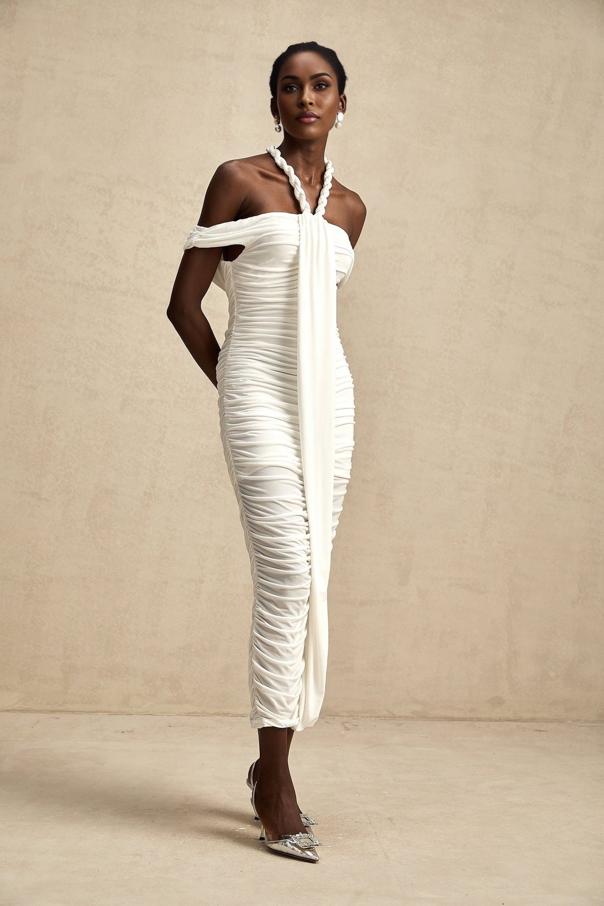 Woman wearing white midi dress with braided rope details and sleeveless design