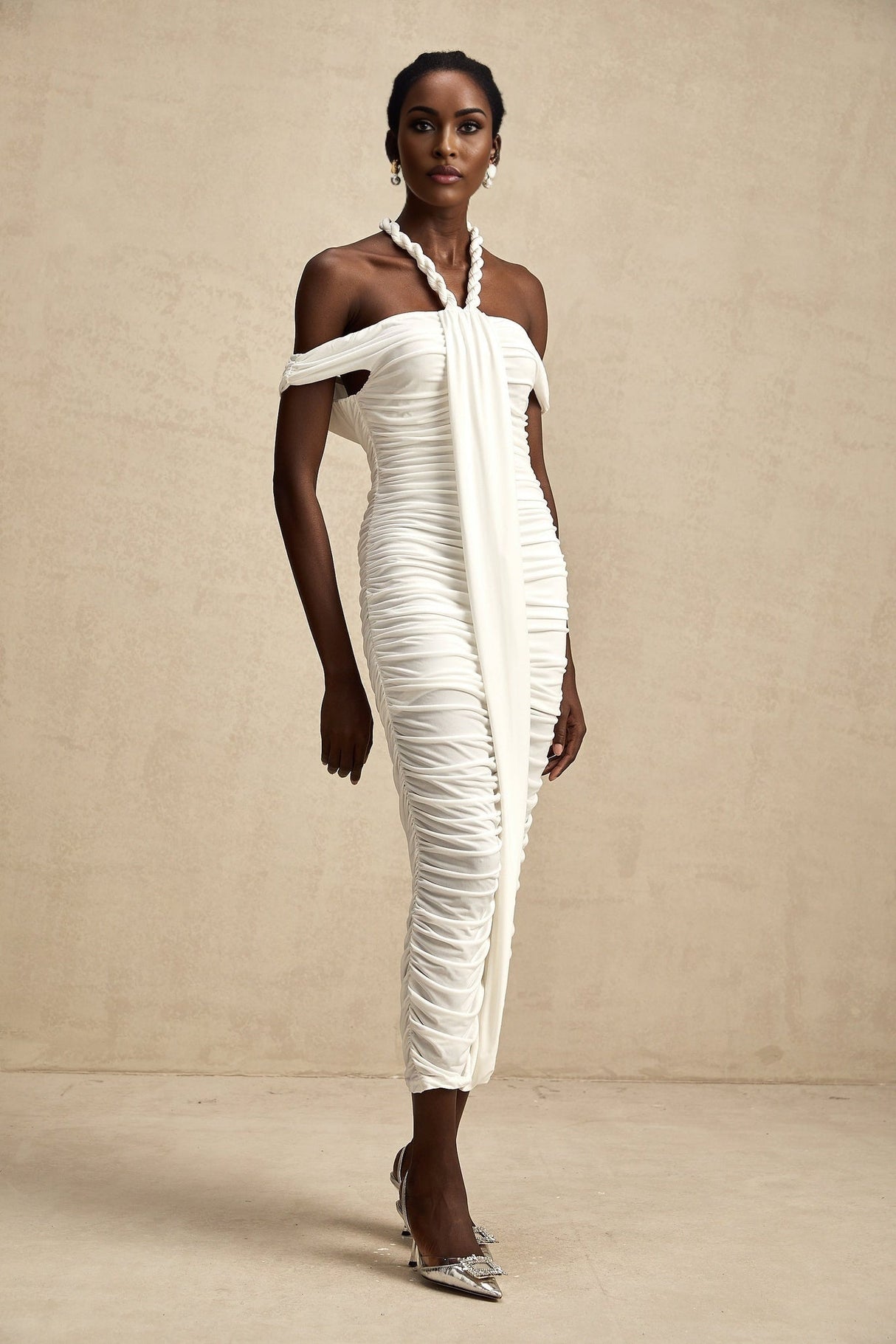 Woman wearing white midi dress with braided rope details and sleeveless design