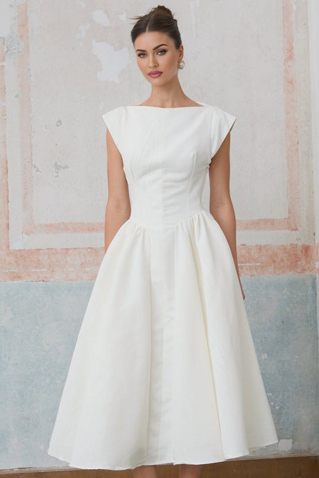 Woman wearing white midi dress with cap sleeves and open back design