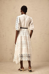 Woman wearing white midi dress with lace trim panels and belt at waist