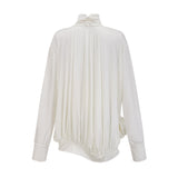 Woman wearing white mini dress with ruched detailing and faux flower embellishments