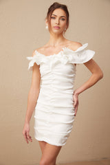 Woman wearing white off shoulder mini dress with ruffled details