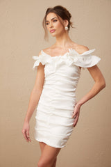 Woman wearing white off shoulder mini dress with ruffled details