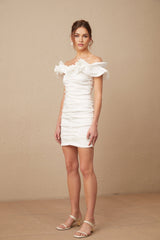 Woman wearing white off shoulder mini dress with ruffled details