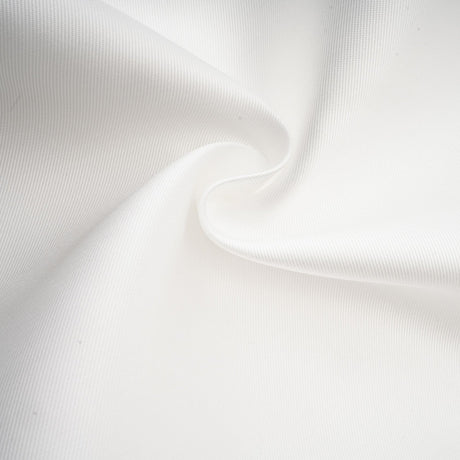 Woman wearing white offshoulder maxi dress with panelled design standing against plain background