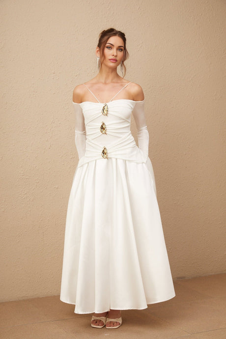 Woman wearing white offshoulder maxi dress with panelled design standing in relaxed pose